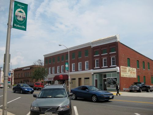 Street view of Wytheville, featuring brick buildings, parked cars, and a street banner.