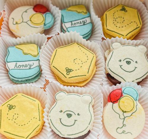 A colorful assortment of honey-themed cookies featuring bear designs and playful decorations in cupcake liners.