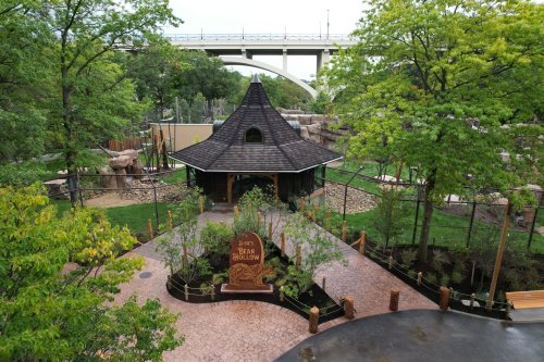 A scenic view of a park featuring a unique building, surrounded by greenery and pathways.