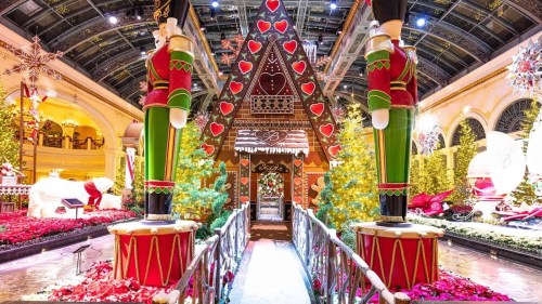 A festive holiday display featuring a gingerbread house, nutcracker figures, and decorated trees in a vibrant setting.