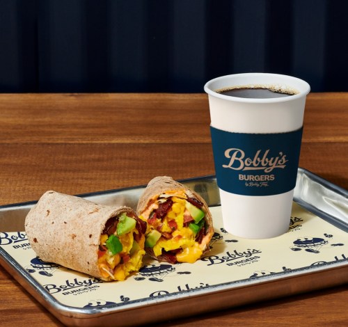 A tray with a breakfast burrito filled with eggs, bacon, and veggies, alongside a coffee cup from Bobby's Burgers.
