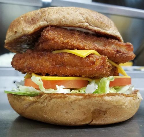 A hearty sandwich with crispy chicken fillets, cheese, lettuce, and tomato, all in a whole grain bun.
