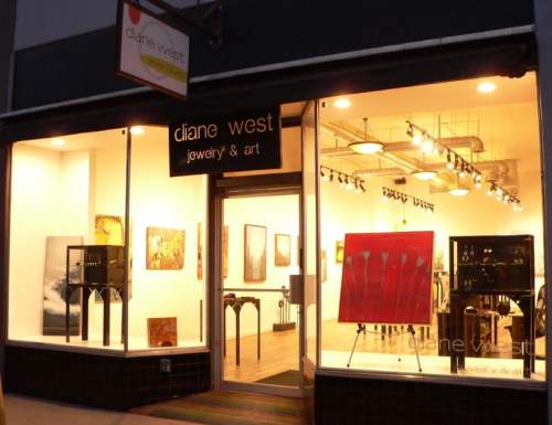 Exterior view of a jewelry and art store named "Diane West," featuring large windows showcasing artwork and jewelry displays.