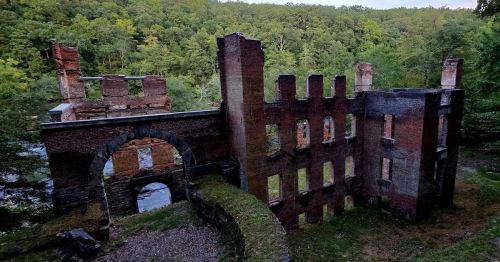 An abandoned mill at Sweetwater Creek State Park with a heavily wooded backdrop.