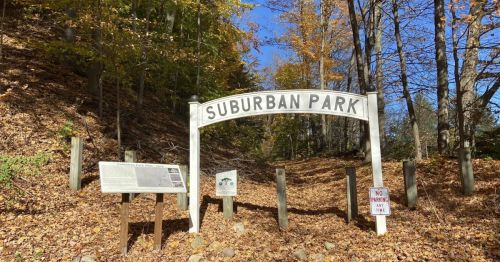 An old arch that says "Suburban Park" marking a trailhead.