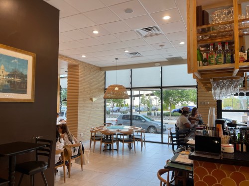 Interior of a restaurant featuring wooden decor, a bar area, and large windows with outdoor views.