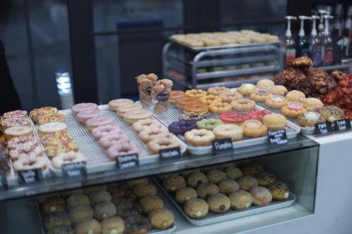 A display case filled with a variety of colorful donuts, including glazed, sprinkled, and filled options.