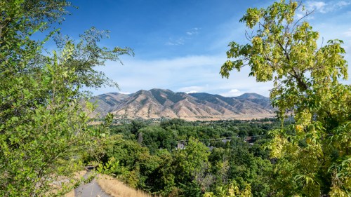 A scenic view of mountains and lush greenery under a clear blue sky.