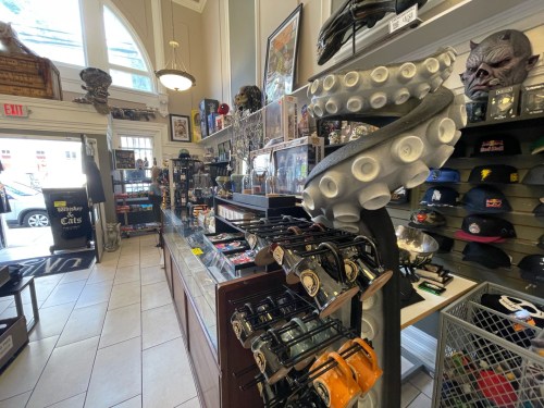 A quirky shop interior filled with collectibles, hats, and unique decor, featuring a prominent octopus sculpture.