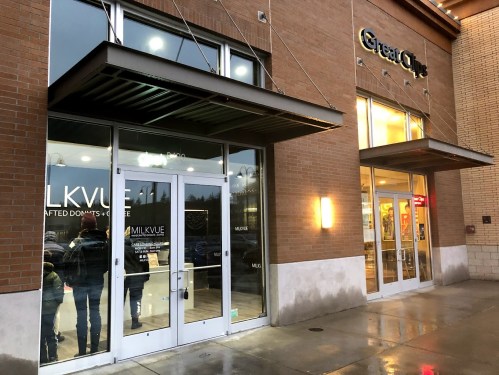 Exterior view of a storefront with large glass doors, featuring the name "MILKVUE" and a sign for "Great Clips" nearby.