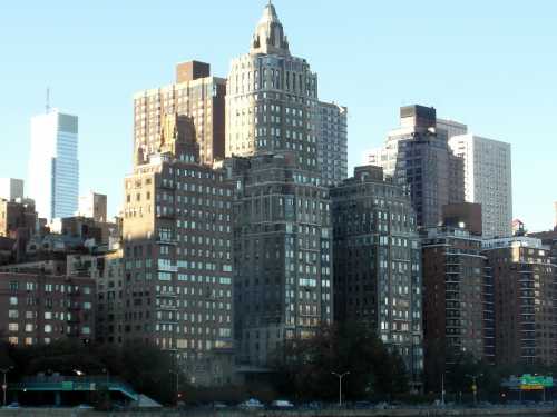 City skyline featuring a mix of historic and modern buildings under a clear blue sky.