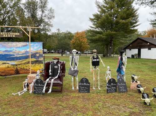 A Halloween display featuring skeletons in various poses, with tombstones and a scenic backdrop at Yellowstone Ranch.