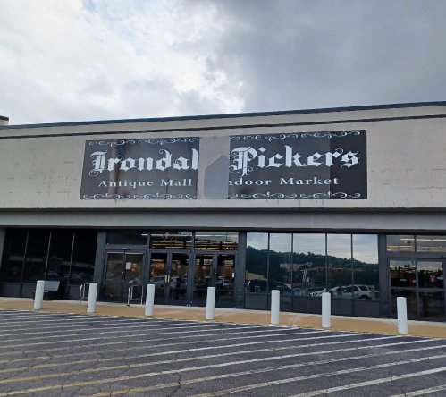 Exterior of Irondale Pickers Antique Mall and Indoor Market, featuring a large sign and entrance with parking in front.