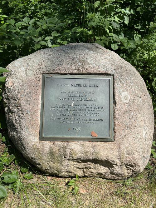 A large rock with a plaque reading "Pasca Natural Area" and details about its designation as a natural landmark, 1965.