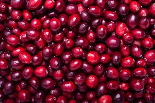 A close-up of a pile of fresh, vibrant red cranberries.