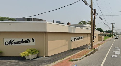 Exterior view of a building with the name "Marcetti's" on the side, located along a street with power lines.