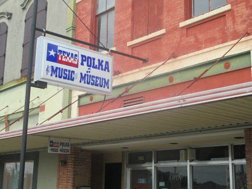 Sign for the Texas Polka Music Museum, featuring colorful lettering and a welcoming entrance.
