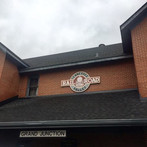 Sign for the Tennessee Railroad on a brick building, with "Grand Junction" visible below. Overcast sky in the background.