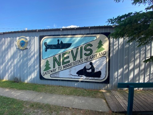 Mural on a building featuring the word "Nevis" and images of boats, highlighting Minnesota's Heartland.