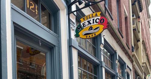 Sign for Villa Mexico Cafe hanging above a storefront, featuring colorful lettering and a decorative design.