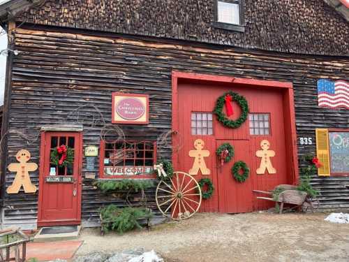 A rustic barn decorated for Christmas with wreaths, gingerbread figures, and a welcoming sign.