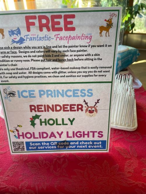 Sign promoting free face painting with designs like ice princess, reindeer, holly, and holiday lights. QR code for services.
