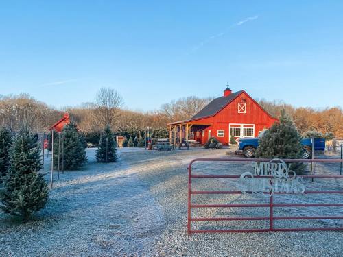 A red barn with a "Merry Christmas" sign, surrounded by frosted trees and a clear blue sky.