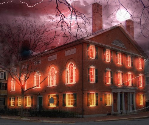 A historic brick building illuminated against a stormy sky with lightning, creating a dramatic and eerie atmosphere.