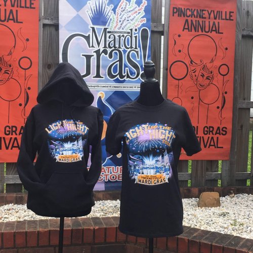 Two Mardi Gras-themed shirts displayed on mannequins, featuring colorful designs and a festive backdrop.