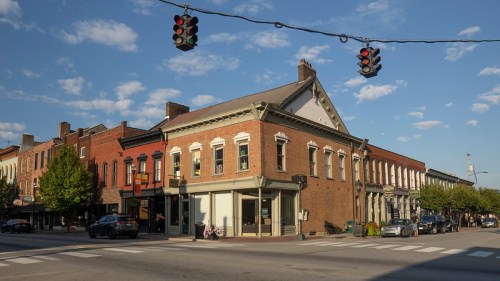 Historic buildings at a street intersection with traffic lights and a clear blue sky.