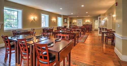 A spacious dining room with wooden tables and chairs, well-lit by natural light from large windows.