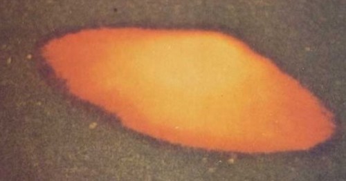 An abstract image featuring an orange, oval shape on a dark background.
