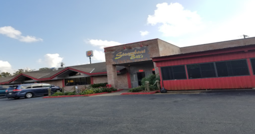 Exterior of a restaurant named "Sangria's Bistro," featuring a red and brick facade with a parking lot.