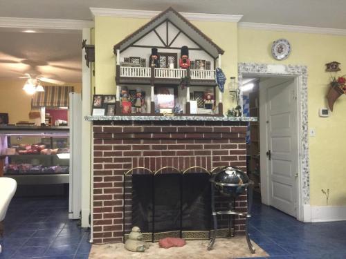 A cozy room featuring a brick fireplace with a decorative model house on top and a blue tiled floor.