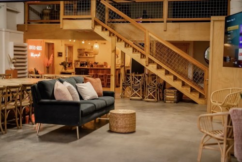 Cozy interior of a modern space featuring a sofa, wooden stairs, and a warm, inviting atmosphere.