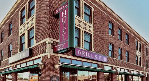 Exterior view of the Arrow Hotel featuring a restaurant and pub, with brick architecture and colorful signage.