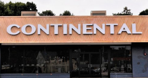 Signage of a building displaying the word "CONTINENTAL" in large, bold letters on a wooden facade.