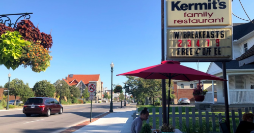 A street view of Kermit's Family Restaurant with a sign advertising breakfast specials and outdoor seating.