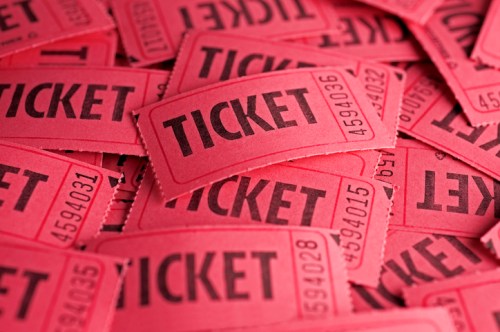 A pile of red raffle tickets with the word "TICKET" printed in bold black letters.