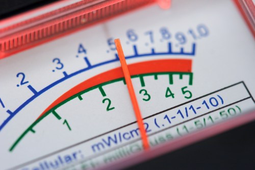 Close-up of a meter displaying readings in mW/cm², with a needle pointing to the 5 mark on a colorful scale.