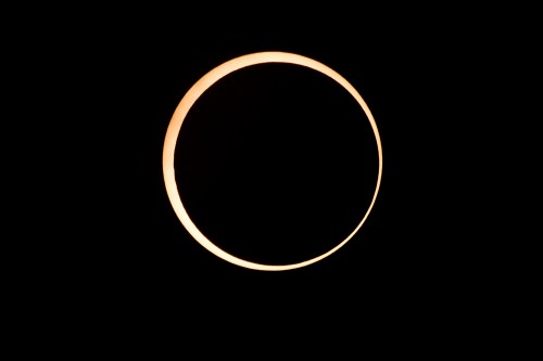 A crescent moon glowing against a dark background, showcasing its illuminated edge.