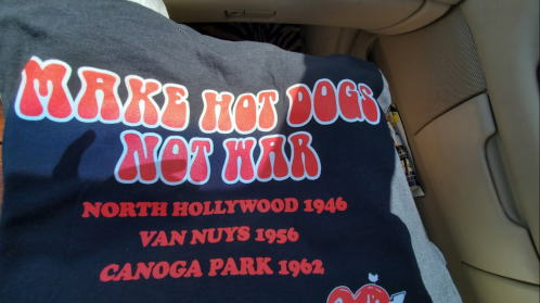 Black t-shirt with the text "MAKE HOT DOGS NOT WAR" and locations with years: North Hollywood 1946, Van Nuys 1956, Canoga Park 1962.