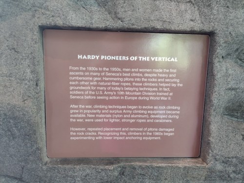 Sign about the history of climbing pioneers from the 1930s to 1950s, detailing their gear and wartime experiences.