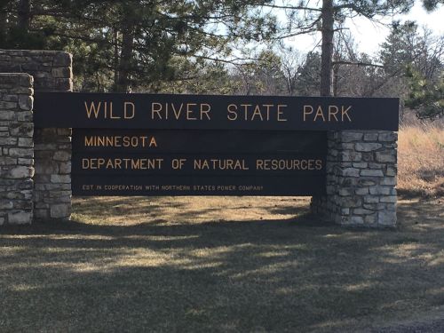 Sign for Wild River State Park in Minnesota, featuring the Department of Natural Resources and stone structure.