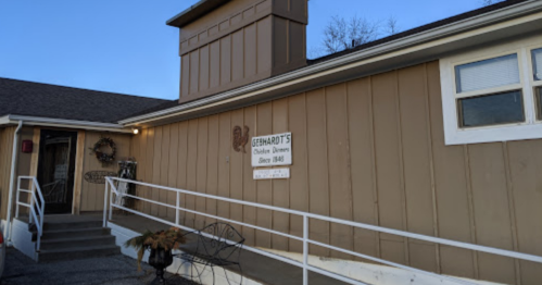 A building with a sign reading "Steinhardt's Children’s Dinners Since 1940," featuring a ramp and a decorative wreath.