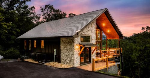 A sunset photo of a luxury cabin in Tennessee on a mountaintop