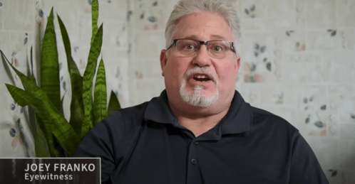 A man with gray hair and glasses speaks, sitting in front of a plant, identified as an eyewitness named Joey Franko.