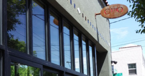 Exterior view of a building with large windows and a sign that reads "Ciro," located on a street corner.