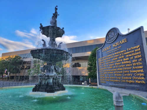A historic fountain in Court Square, with a plaque detailing its significance and nearby buildings in the background.