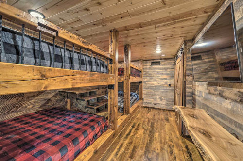 Cozy wooden interior with bunk beds, plaid bedding, and rustic decor, creating a warm, inviting atmosphere.
